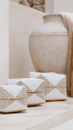 three white bags sitting on top of a table next to a vase and other items