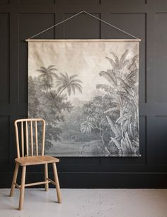 a chair sitting in front of a tapestry hanging on a wall