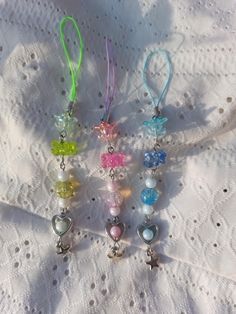 six different colored beads and charms on a white doily