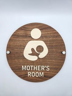 a wooden sign that says mother's room on the side of a white wall