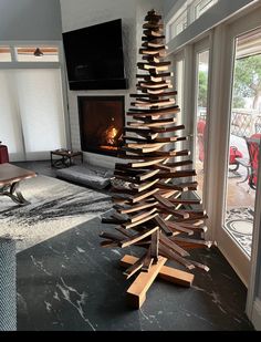 a wooden christmas tree sitting in front of a fire place