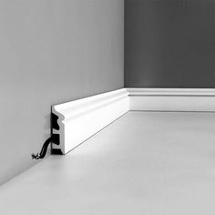 a black and white photo of a corner with a door handle on the wall next to it