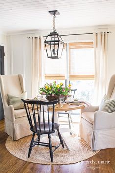 a dining room table with chairs and a light fixture hanging from the ceiling above it