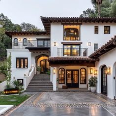 a large white house with lots of windows and steps leading up to the front door