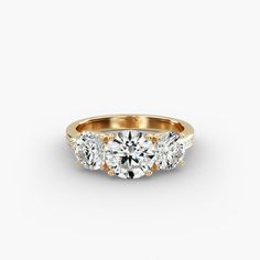 three stone diamond ring in yellow gold with diamonds around the band and sidestones on each side