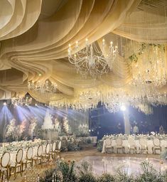 a banquet hall with chandeliers, tables and chairs