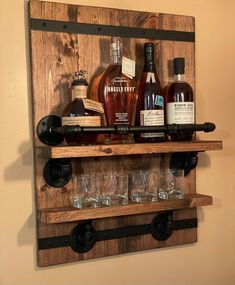 a wooden shelf filled with bottles and glasses on top of a wall mounted wine rack