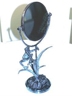 a mirror sitting on top of a metal stand