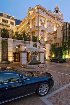 a black car parked in front of a hotel