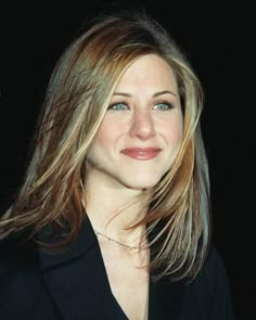 a woman with blonde hair and blue eyes smiles at the camera while wearing a black blazer