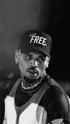 a black and white photo of a man wearing a hat with the word free on it