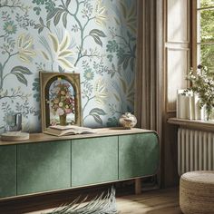 a room with a green cabinet and wallpaper on the walls, next to a window