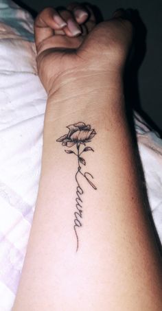 a woman's arm with a tattoo on it that says love and a flower