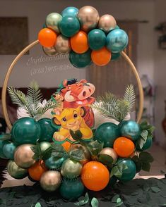 the lion king balloon arch is decorated with oranges, green and gold balloons as well as other decorations