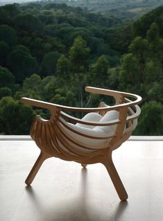 a wooden chair sitting on top of a hard wood floor next to a large window