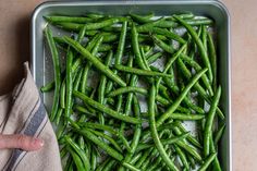 green beans in a metal pan on a counter top with a napkin next to it