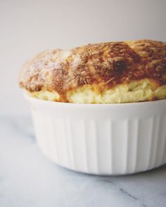 a close up of a baked item in a bowl on a table top with a white background