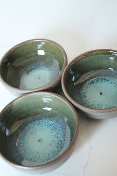 three bowls sitting on top of a white table