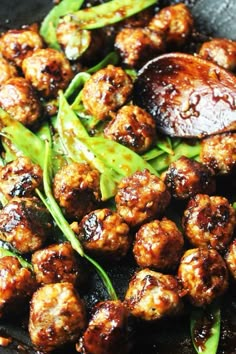 some meatballs and vegetables are cooking in a skillet