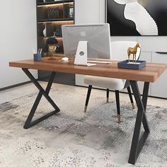 a desk with a laptop and a horse figurine sitting on top of it