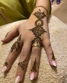 a woman's hand with henna tattoos on it