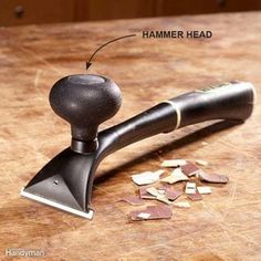 an image of a hammer head on top of a cutting board with chopped up wood shavings