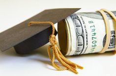 a graduation cap sitting on top of a stack of money