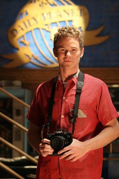 a man standing in front of a building holding a camera