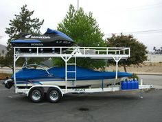 a blue and white boat is parked in a parking lot next to a house with a cover over it