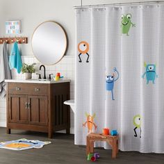 a child's bathroom with monsters on the shower curtain