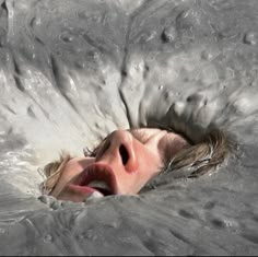 a woman is submerged in the water with her eyes closed