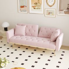 a living room with pink couches and pictures on the wall above it, along with a coffee table