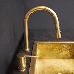 a gold sink and faucet in a bathroom