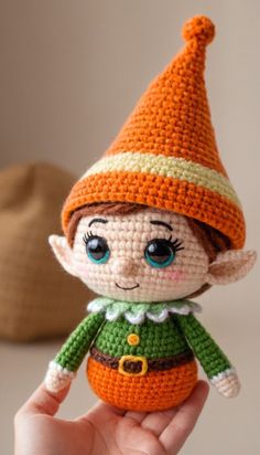 a small crocheted elf doll is shown in the palm of someone's hand