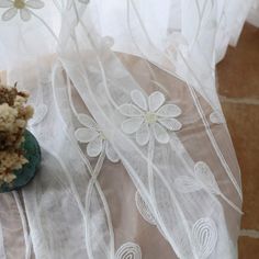 a small potted plant sitting on top of a table covered in white sheers