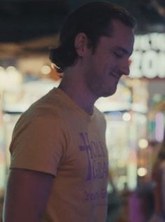 a man standing in front of a store with his eyes closed and smiling at the camera