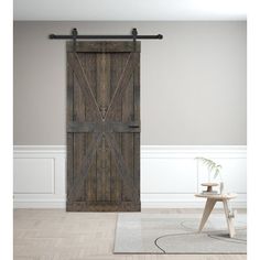 an open wooden door in a room with white walls and wood flooring, along with a rug on the floor