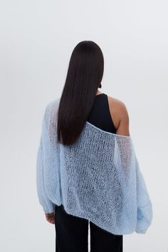 the back of a woman wearing a blue sweater