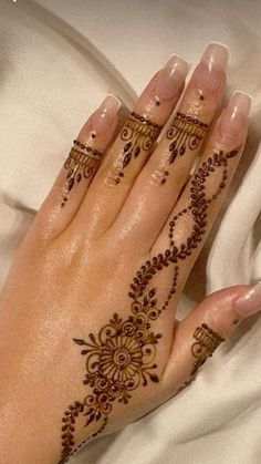 a woman's hands with henna tattoos on them