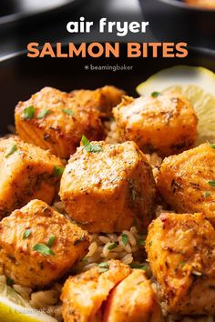 a plate full of salmon bites with rice and lemon wedges