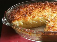 a casserole dish with a piece missing from it on a red tablecloth