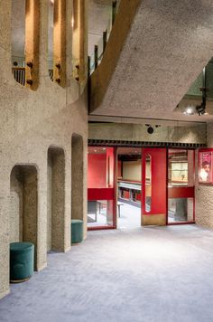 an empty room with red doors and stairs