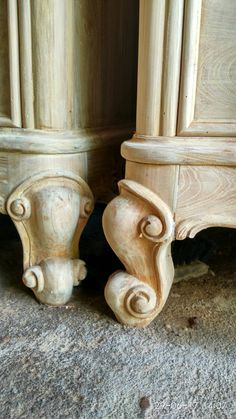 two carved wooden pillars on the ground next to each other, with one leaning against the wall