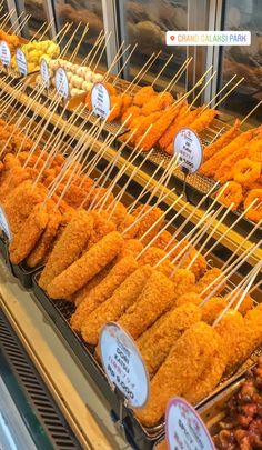 chicken skewers are lined up in a display case