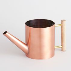 a copper colored coffee mug with a wooden handle