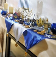 the table is covered with blue and white linens, candles, and other items