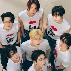 the group of young men are posing together for a photo in white t - shirts