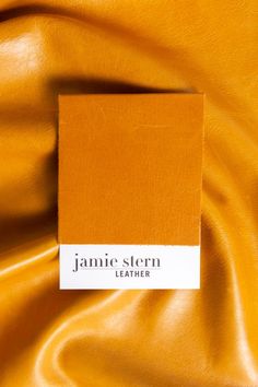 A cutting of Jamie Stern Trento Sunflower leather is pictured on top of a full hide of the same leather. Trento Sunflower is a rich, golden yellow. Leather Photography, Leather Aesthetic, Poster Background Design, Yellow Aesthetic, Leather Furniture, The Square, Orange Leather, Pull Up