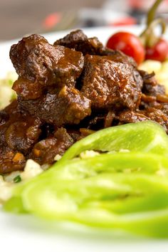 beef stew served with rice and vegetables on a white plate, with the caption hungarian beef stew