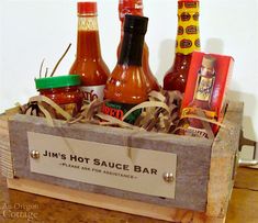 a wooden box with hot sauces and condiments in it sitting on a table